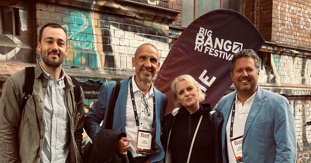 Vertreter von ACISO und INJOY vor Flagge des Big Bang Festivals
