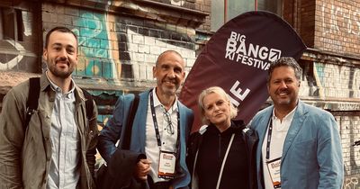 Vertreter von ACISO und INJOY vor Flagge des Big Bang Festivals