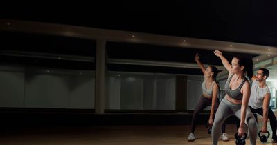 2 Frauen und ein Mann beim Kettlebell-Training im Kursraum 