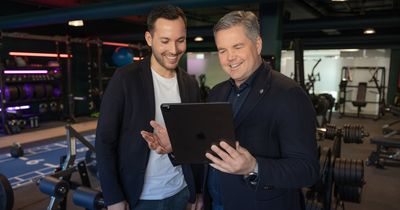 Christian Hörl zeigt einem Fitnessstudiobetreiber etwas auf einem Tablet