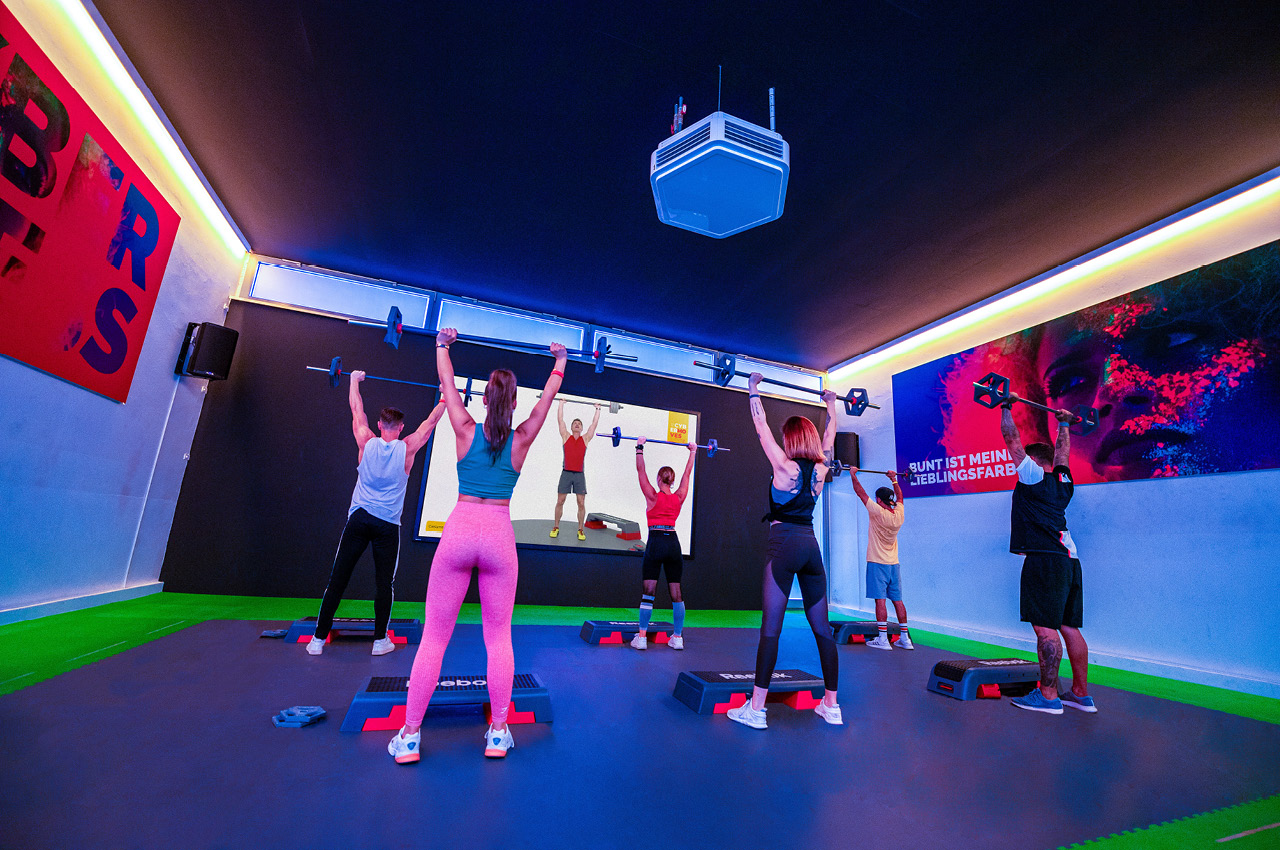 Fitnessstudiomitglieder trainieren mit digitalem Bildschirm