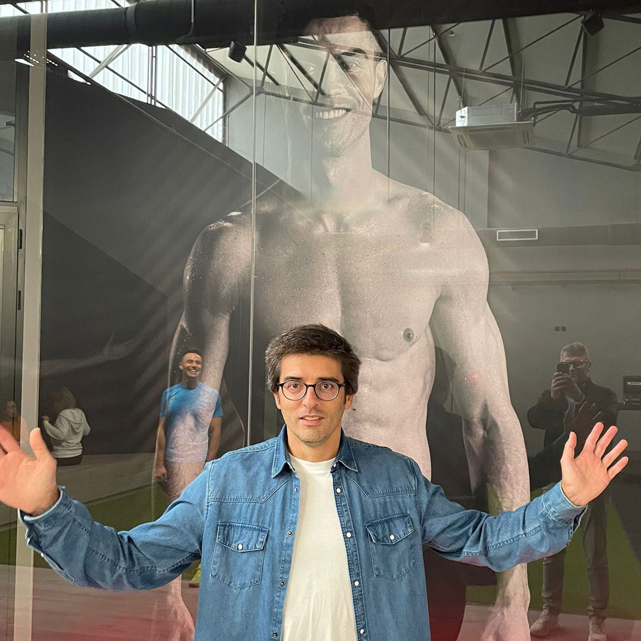 Ein Mitarbeiter des CR7 Fitness by Crunch  steht vor einer großen Glaswand mit einem Foto von Cristiano Ronaldo