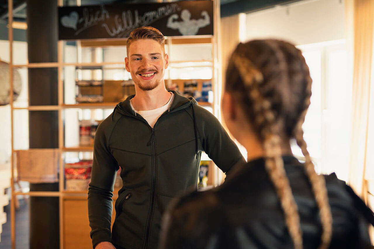 Trainer und Fitnessstudiomitglied im Dialog