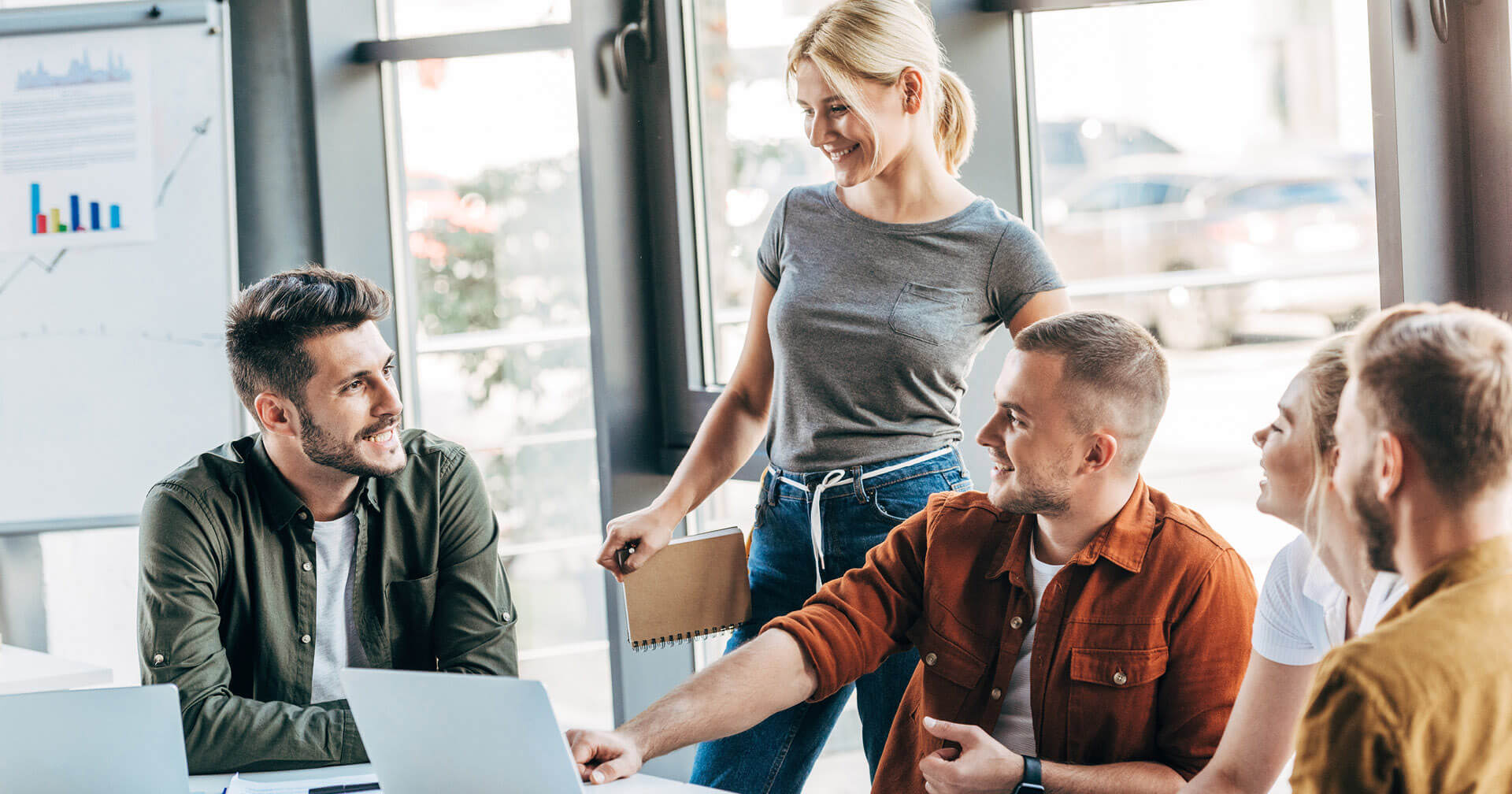 Eine Gruppe an Mitarbeitern im Büro vor einem Laptop