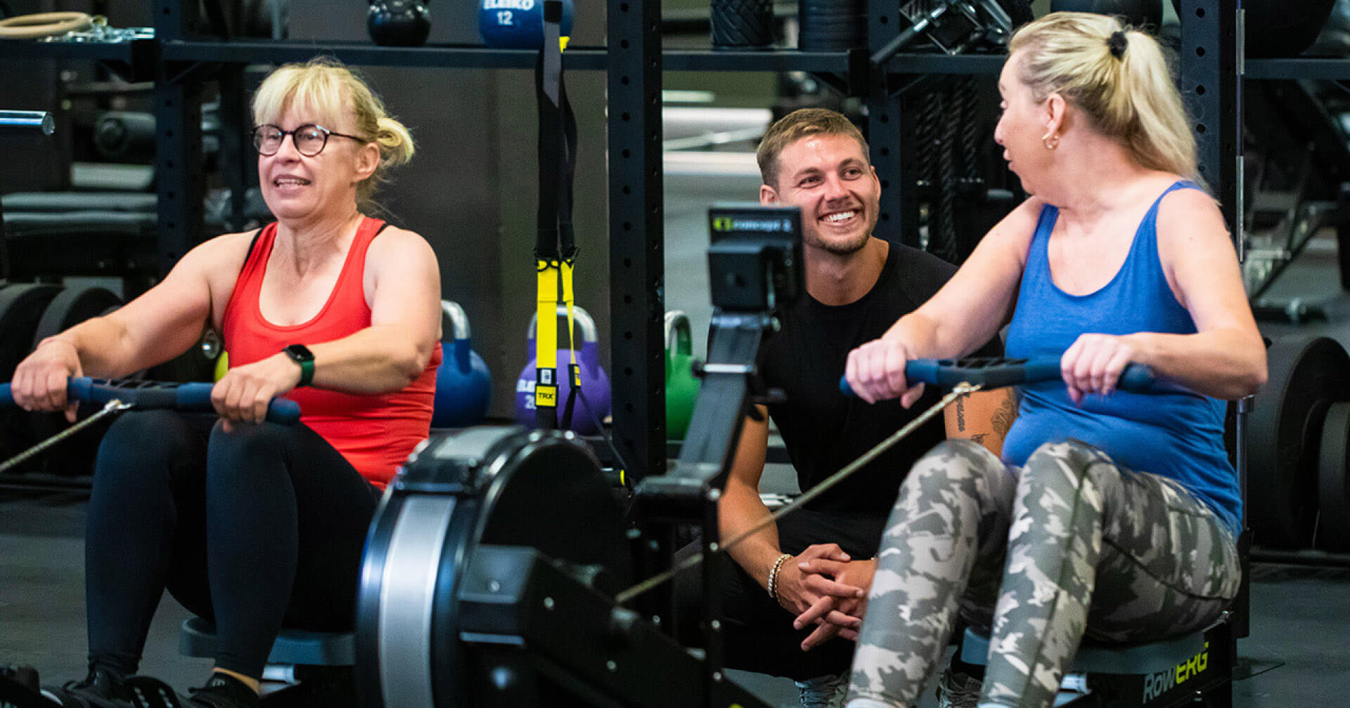 Zwei ältere Damen trainieren unter Aufsicht von Trainer