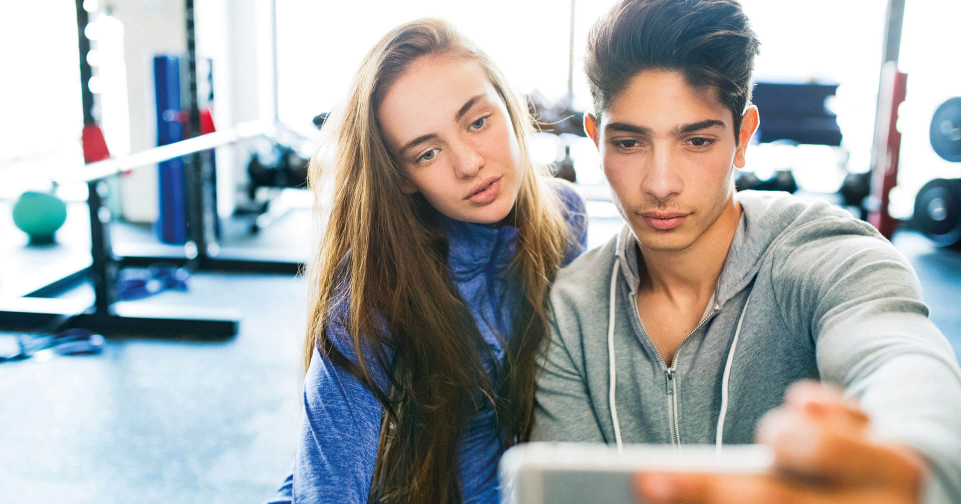 Junge und Mädchen machen Selfie in einem Fitnessstudio