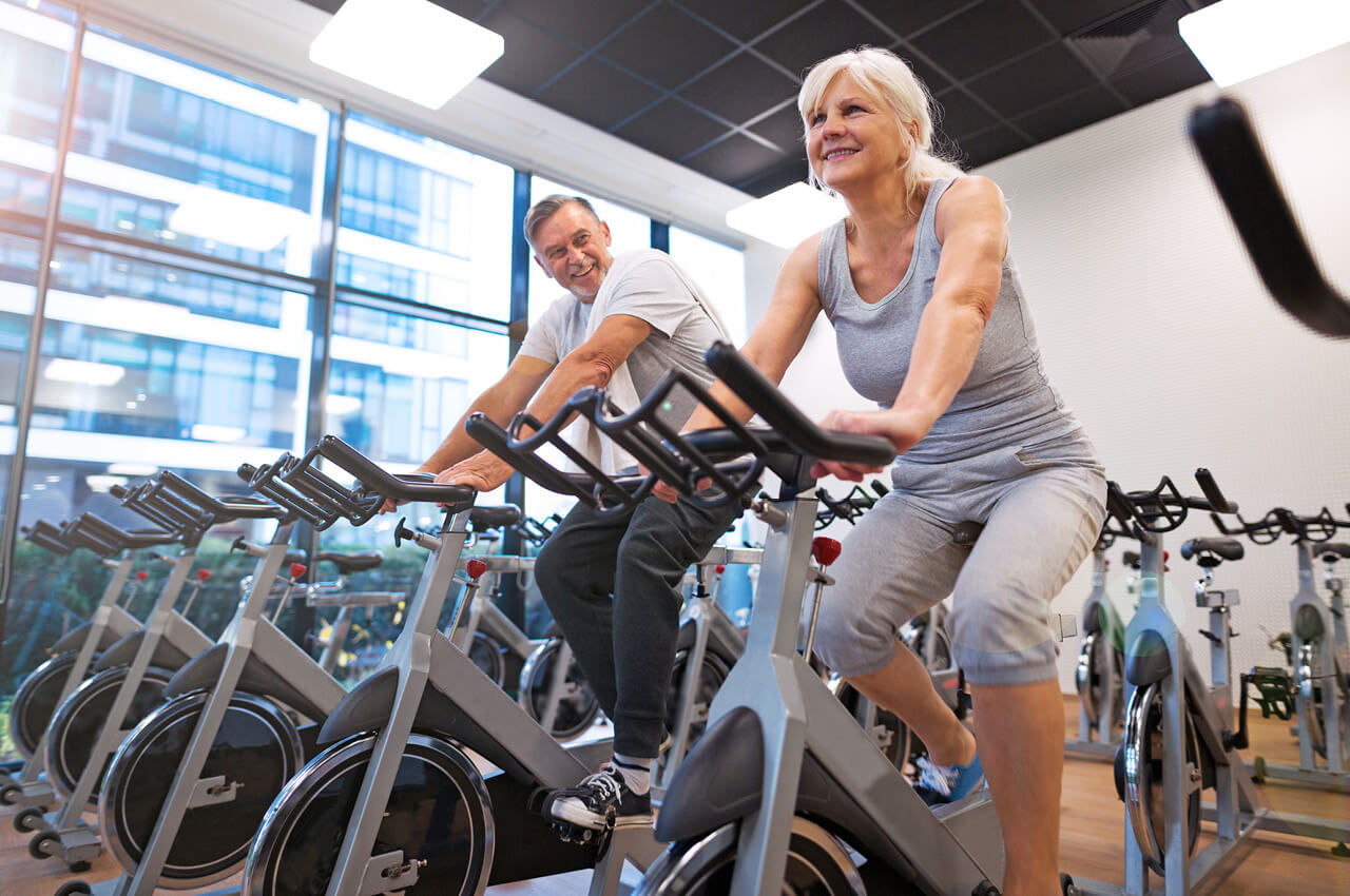 Regelmäßiges Training ist wichtig, jedoch ist es nicht alleine entscheidend für die Langlebigkeit Älteres Paar Training auf einem Fahrrad