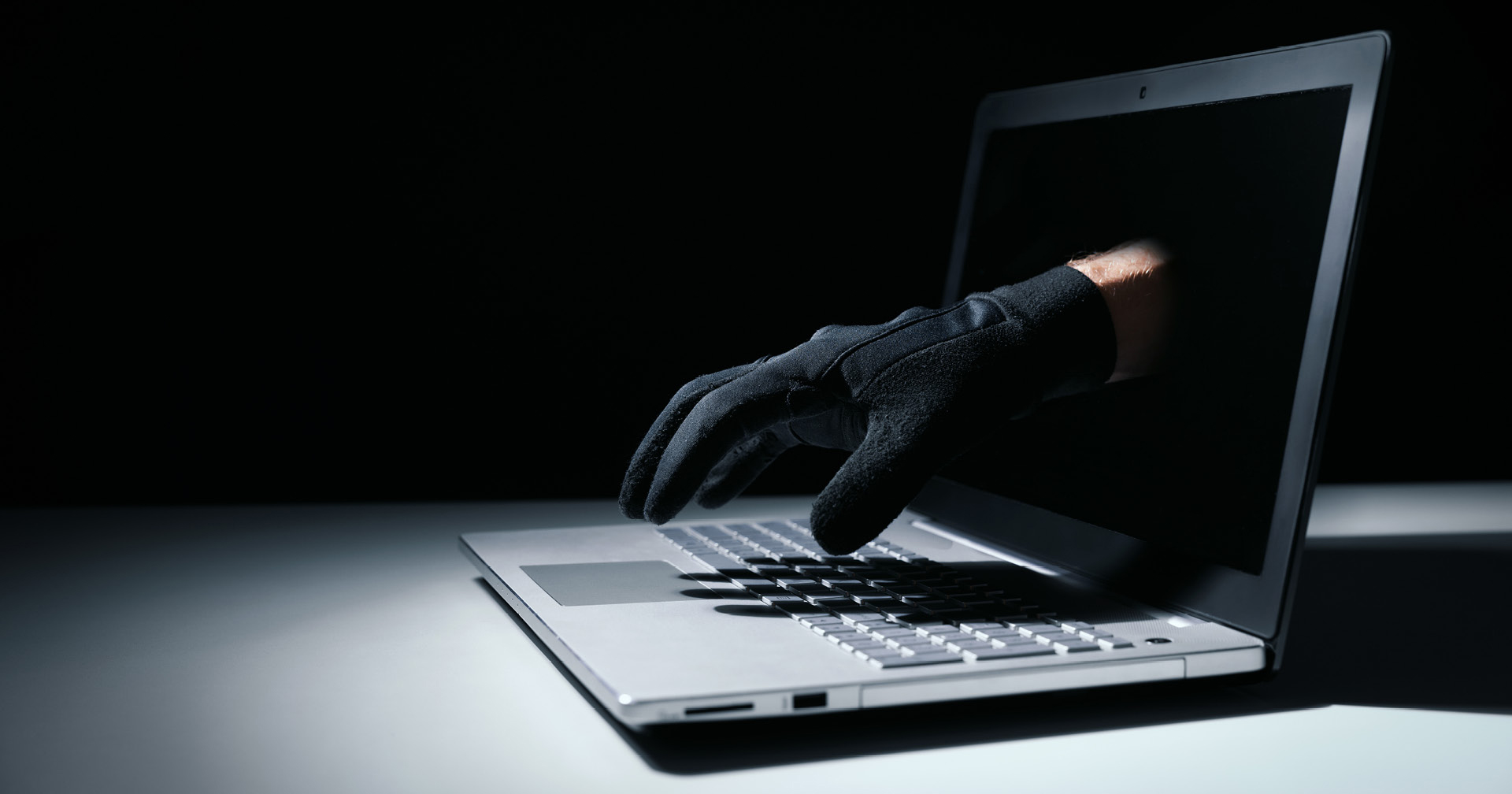 Hackerhand kommt aus dem Bildschirm eines PCs heraus