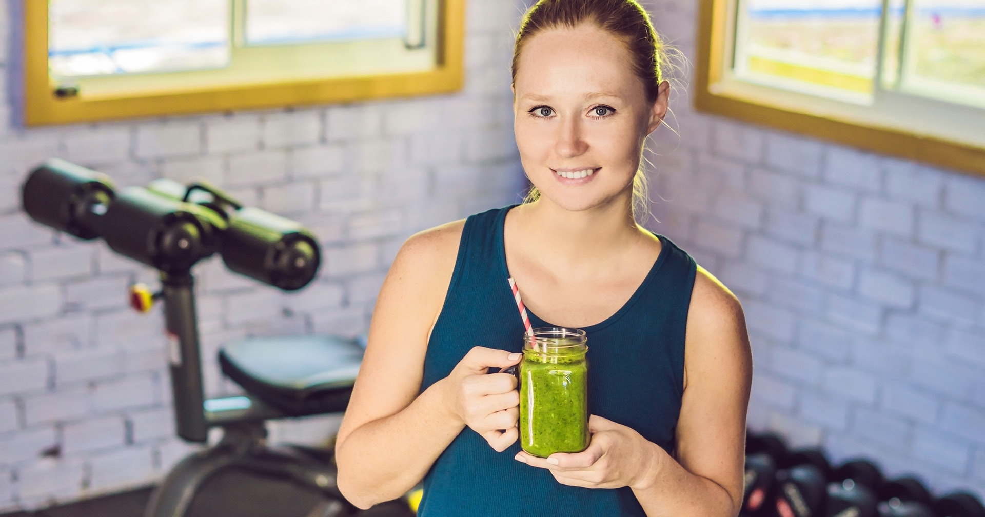 Fitnessstudiomitglied hält einen Smoothie in der Hand