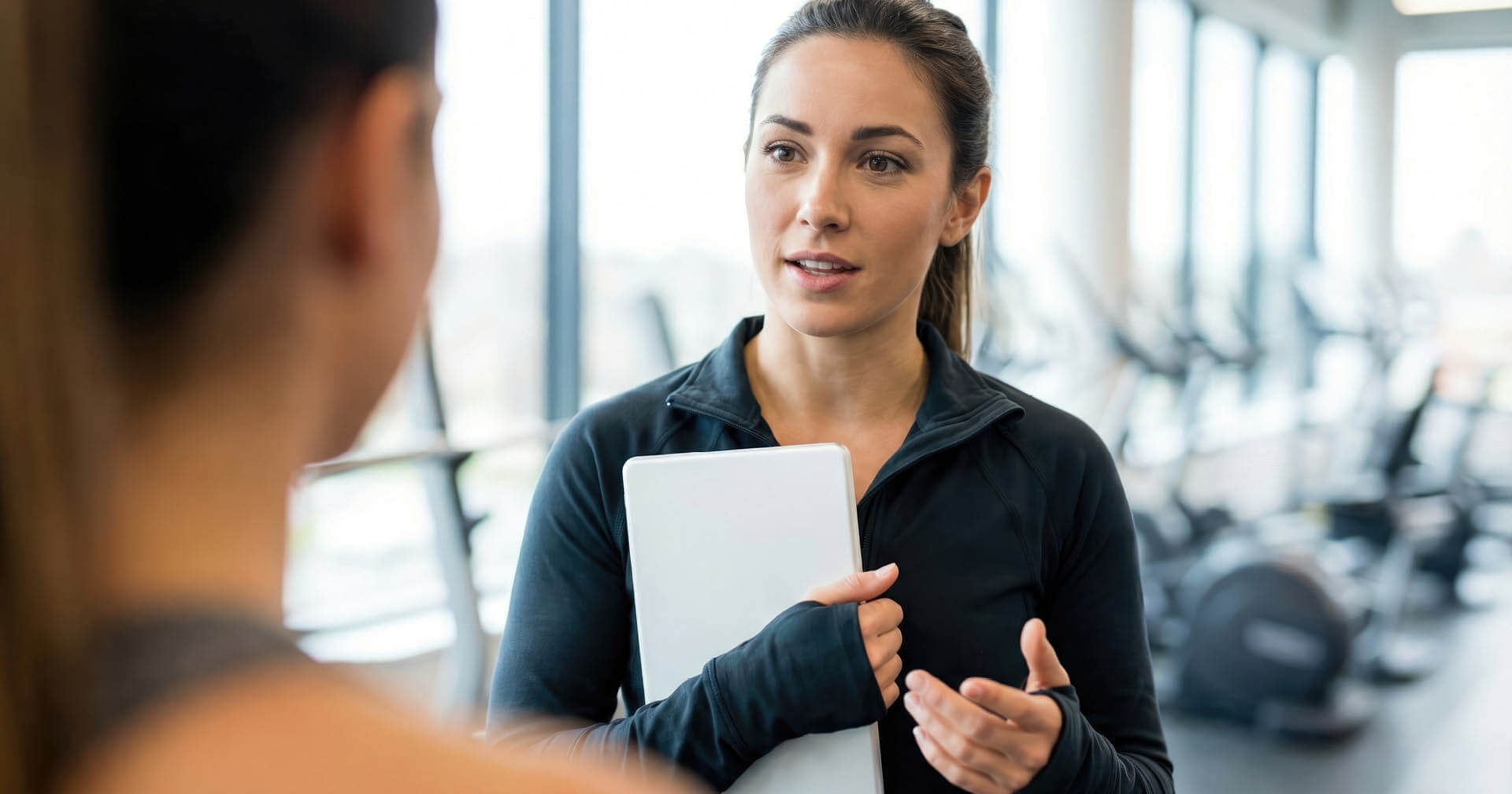 Manager im Fitnessstudio spricht mit neuem Mitarbeiter über zukünftige Aufgaben