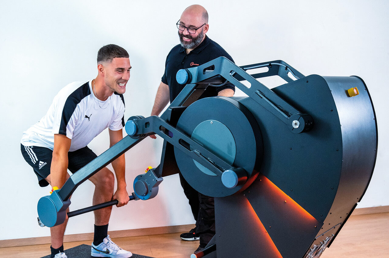 Sparkfield entwickelt die erste robotikbasierte Kraftlösung, die eine neue Trainingskategorie eröffnet Prof. Dr. Amos Albert mit einem Sportler, der am Sparkfield Core trainiert