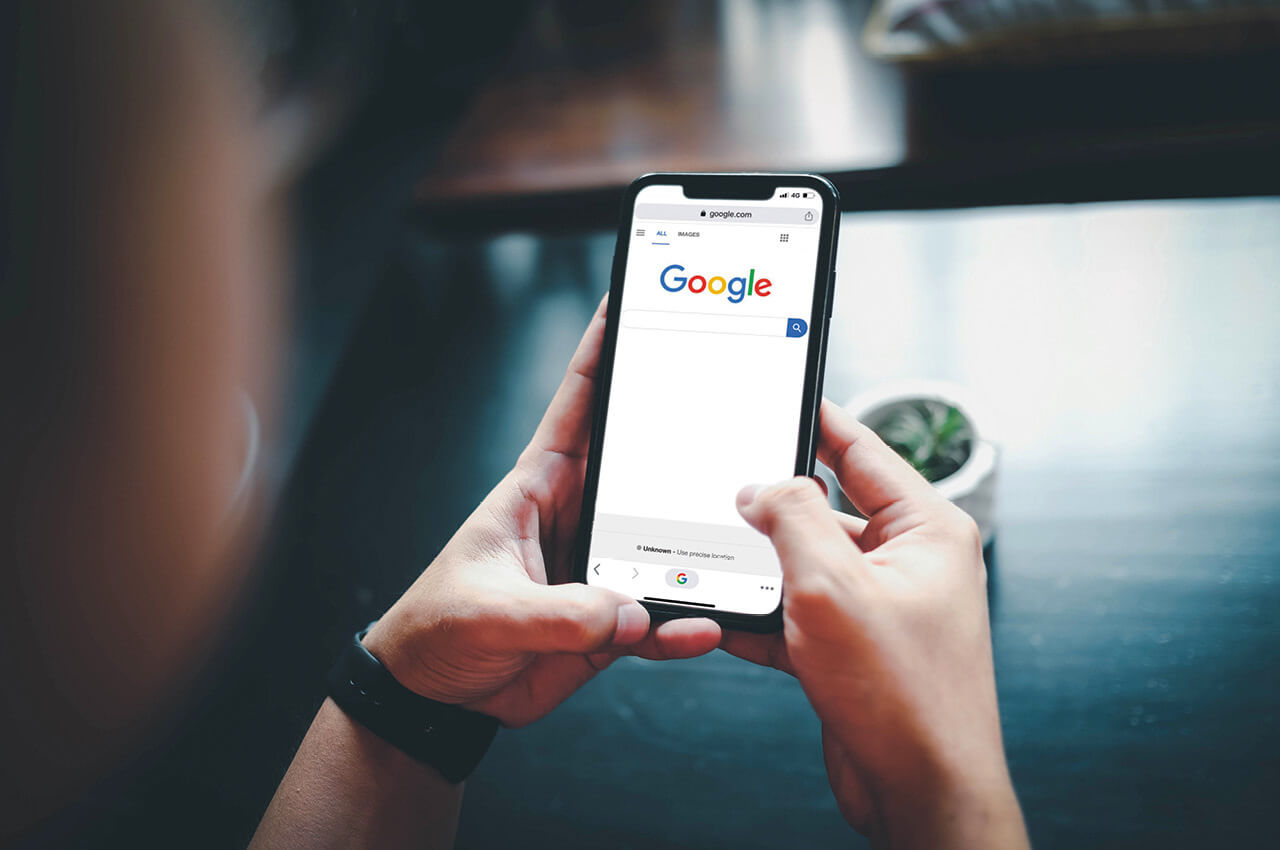Person googelt etwas auf einem Smartphone