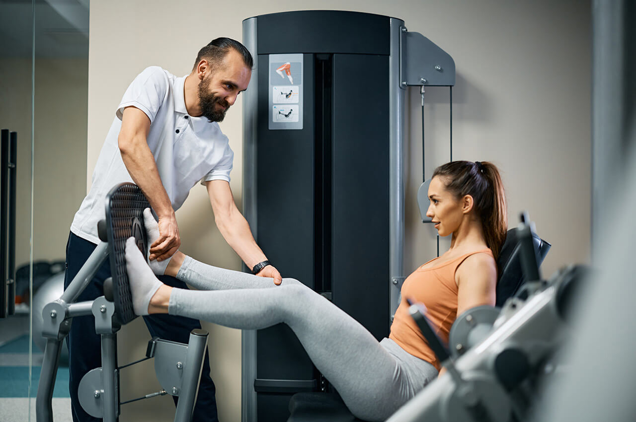 Physiotherapeut mit Patientin beim Beintraining