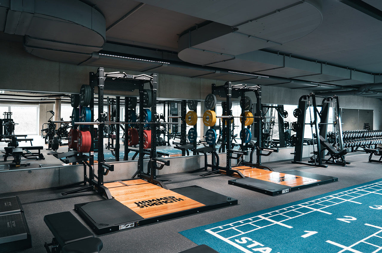 Der Innenbereich eines Fitnessstudios mit unterschiedlichen Geräten.