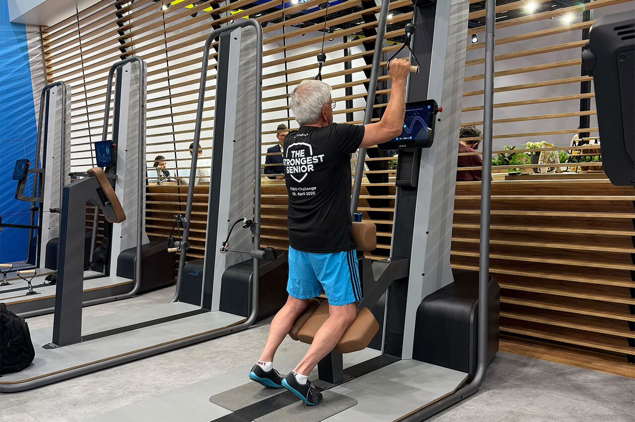 Auf der Fibo testet ein älterer Mann ein Gerät von milon