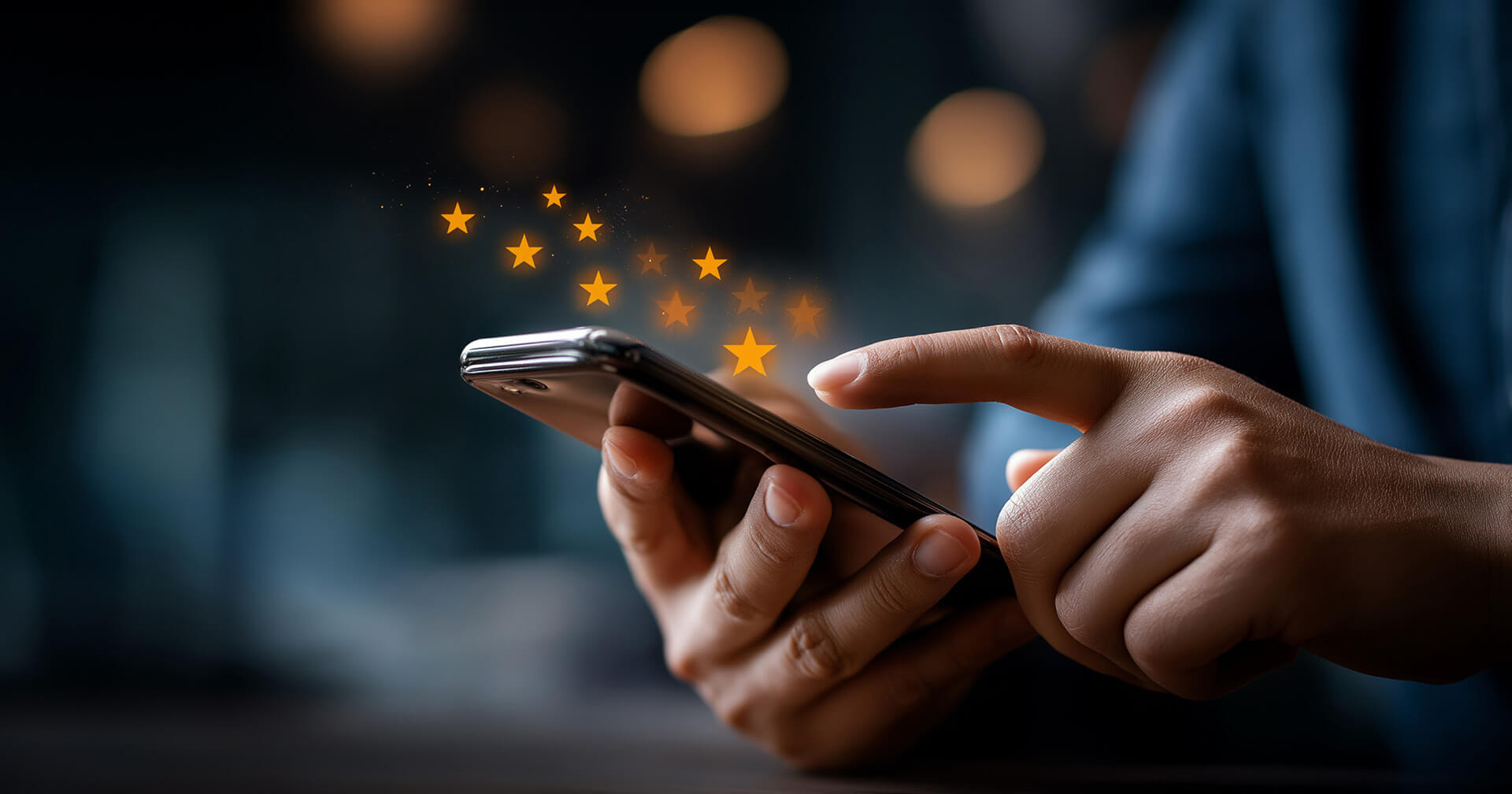 Nahaufnahme von Händen, die ein Smartphone bedienen. Über dem Display schweben mehrere leuchtend gelbe Sterne als Symbol für digitale Kundenbewertungen. Der Hintergrund ist dunkel und stimmungsvoll mit unscharfen Lichtpunkten (Bokeh-Effekt) gestaltet.
