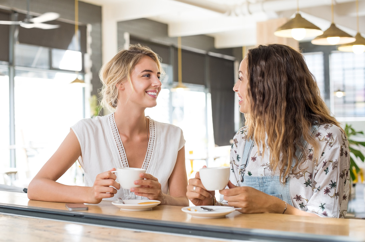 Zwei Frauen sprechen und trinken Kaffee