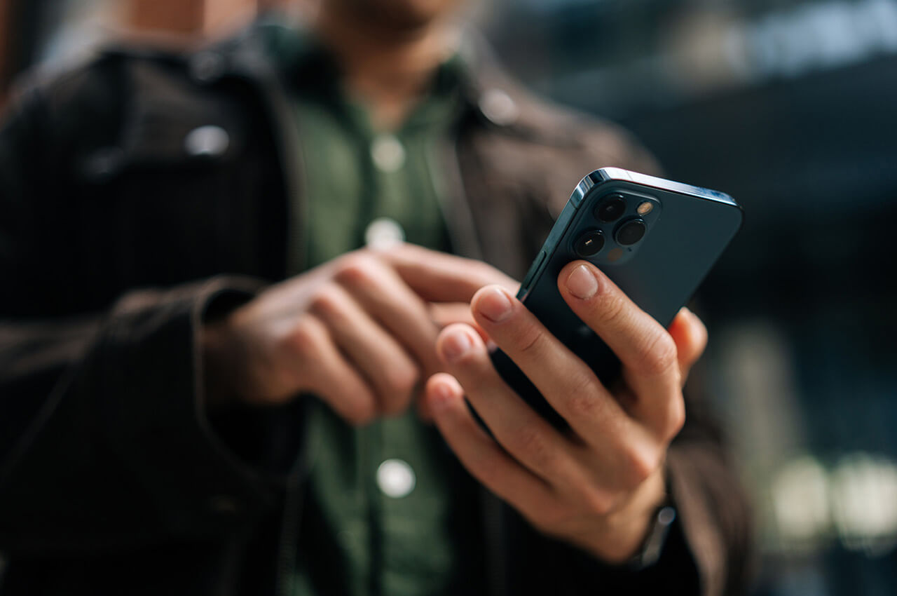 Ein Mann hält ein Smartphone in der Hand.