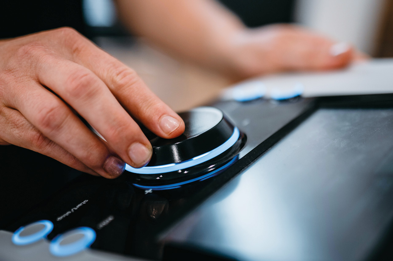Eine Hand, die an einem technischen Gerät einen Regler dreht