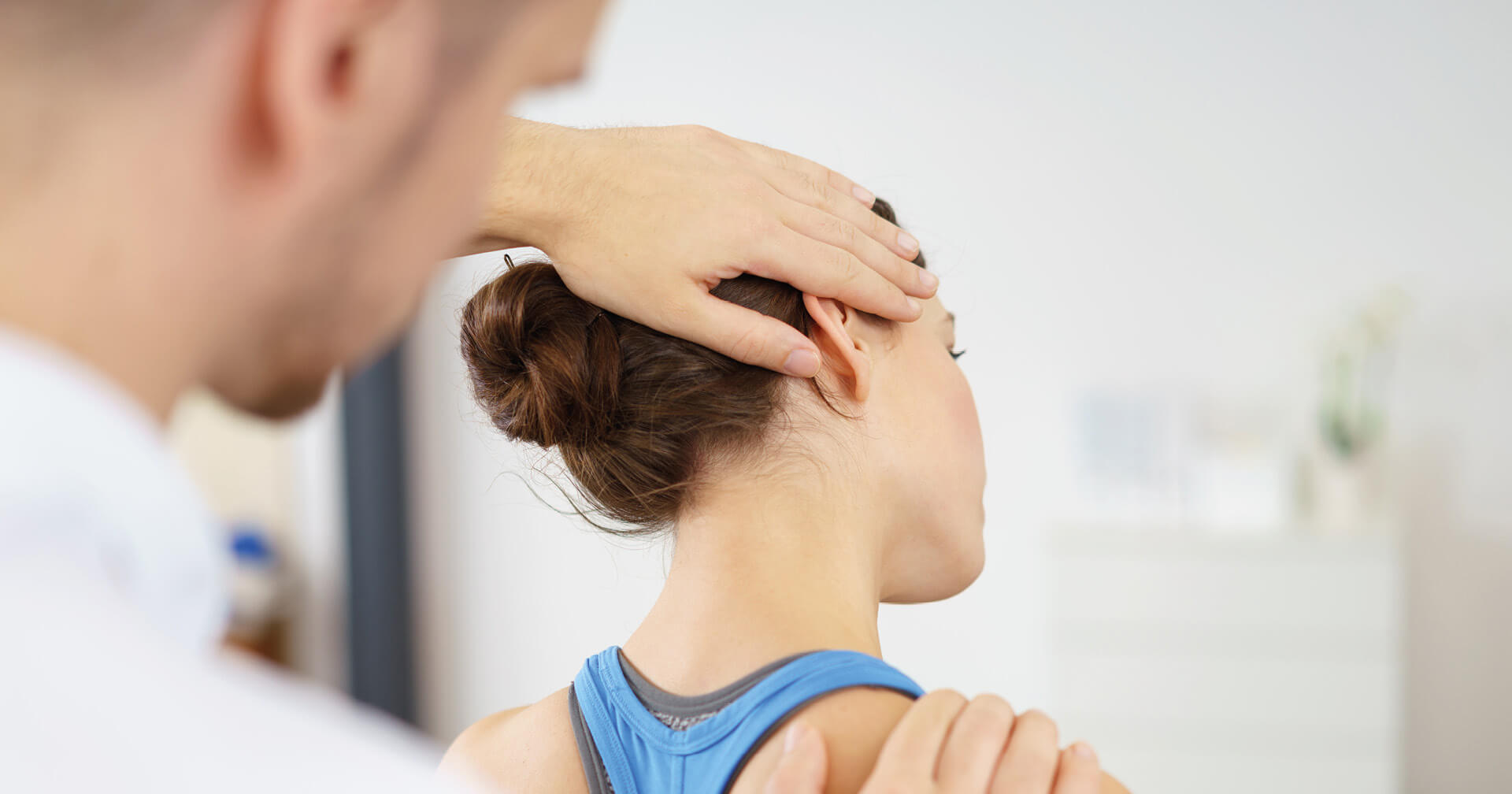 Physiotherapeut dehnt Nacken einer Frau