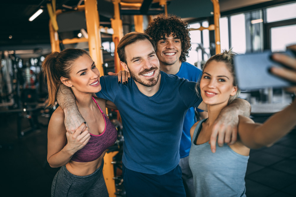 Fitnesstrainer machen ein Selfie im Fitnessstudio