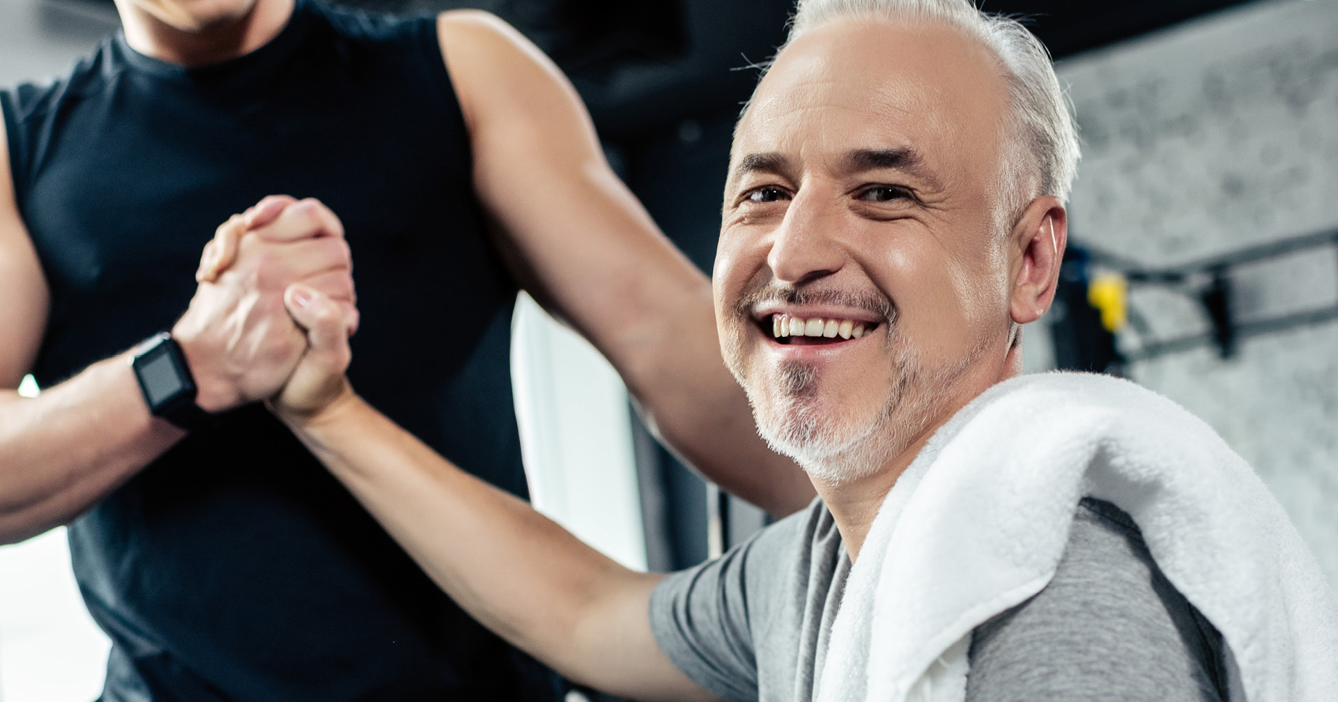 Mann gibt seinem Trainer nach dem Fitnesstraining die Hand