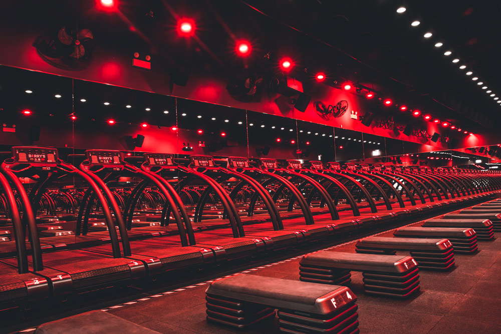 Ein rotbeleuchteter Kardiobereich in einem elbgym